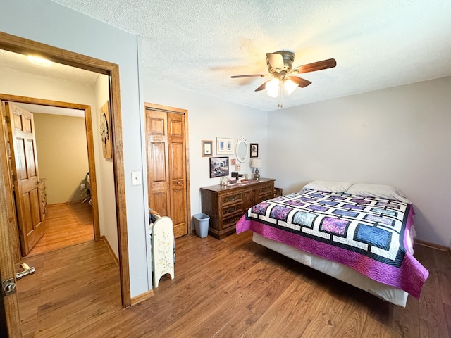 bedroom with a closet, light wood-style flooring, and a textured ceiling