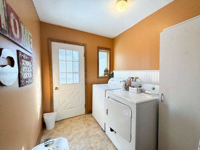 laundry room featuring light tile patterned floors, separate washer and dryer, and laundry area