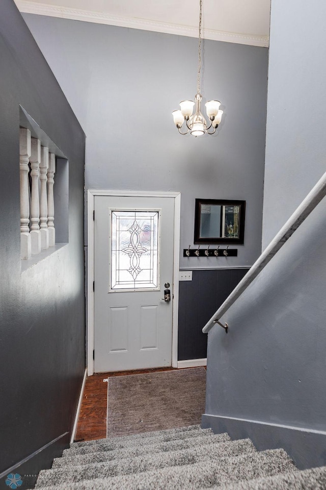 foyer entrance featuring crown molding and a chandelier