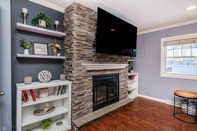 living room with hardwood / wood-style floors, crown molding, and a stone fireplace