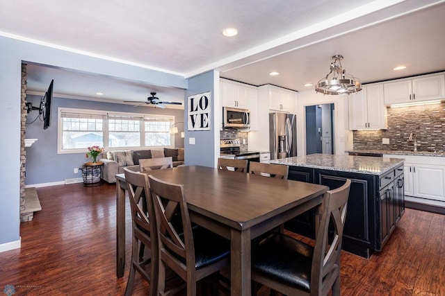 dining area with ceiling fan, sink, and dark hardwood / wood-style flooring