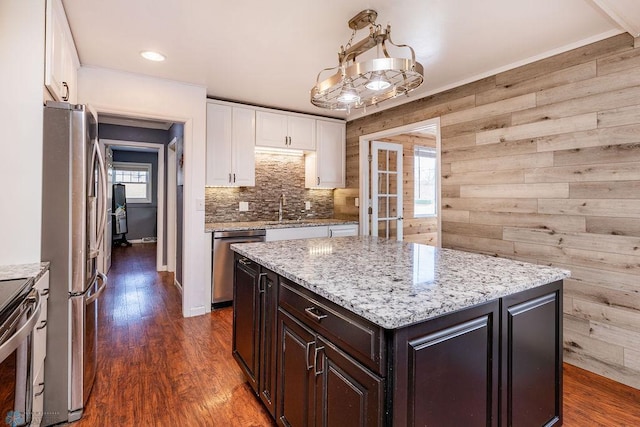 kitchen with white cabinetry, stainless steel appliances, dark hardwood / wood-style floors, dark brown cabinetry, and a kitchen island