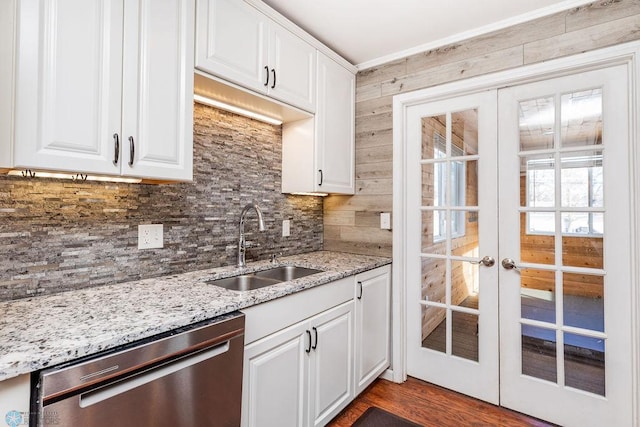 kitchen with french doors, sink, dishwasher, white cabinets, and backsplash