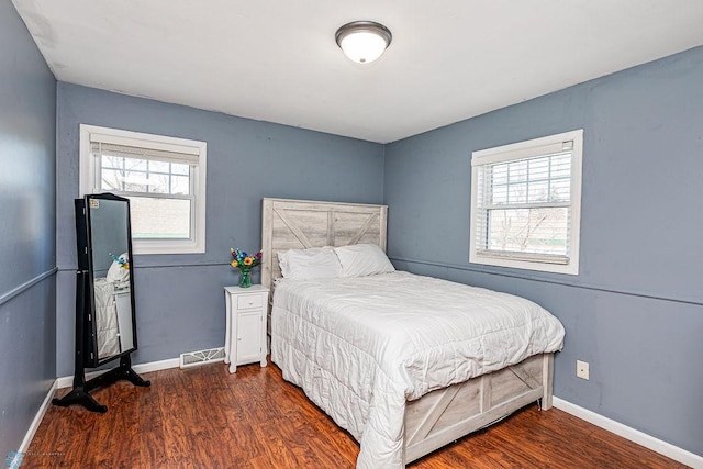 bedroom featuring dark wood-type flooring and multiple windows