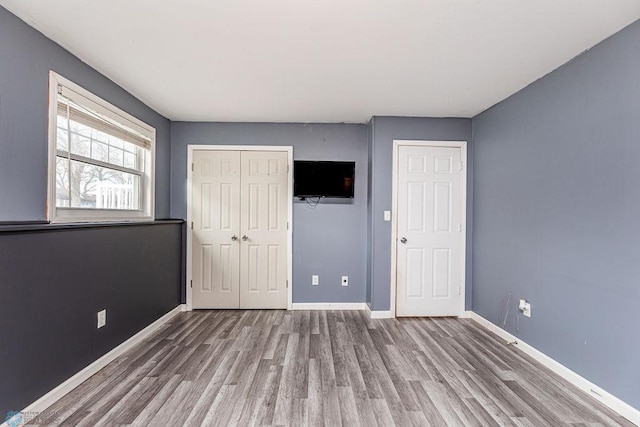 unfurnished bedroom featuring wood-type flooring and a closet