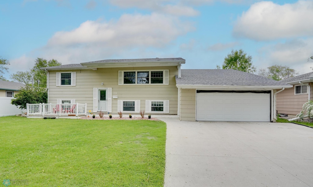 324 Cherry Ct, West Fargo, ND 58078 - bi-level home featuring a garage, driveway, a front lawn, and a wooden deck