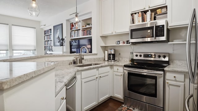 kitchen featuring pendant lighting, sink, white cabinetry, and stainless steel appliances