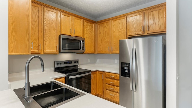 kitchen featuring appliances with stainless steel finishes, sink, and a textured ceiling