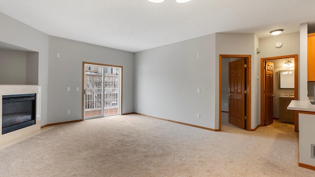 unfurnished living room with light carpet and a textured ceiling