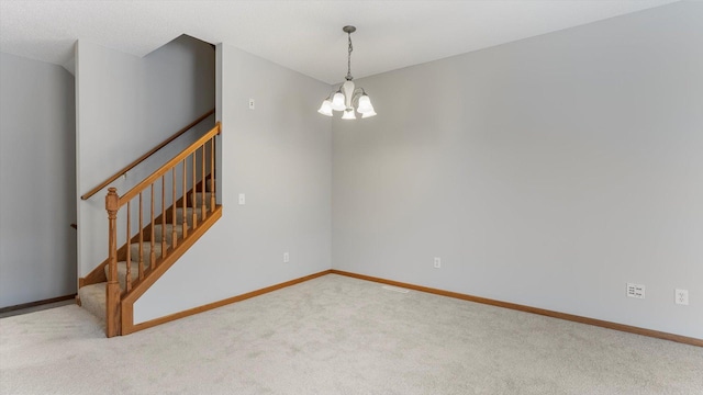 carpeted spare room with a notable chandelier