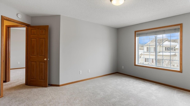 carpeted spare room featuring a textured ceiling