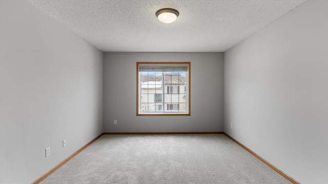 carpeted empty room with a textured ceiling