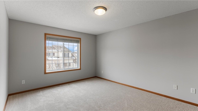 carpeted empty room featuring a textured ceiling