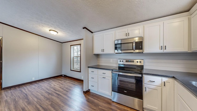 kitchen featuring appliances with stainless steel finishes, a textured ceiling, white cabinets, and dark hardwood / wood-style flooring