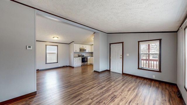 unfurnished living room featuring crown molding, lofted ceiling, a wealth of natural light, and dark hardwood / wood-style flooring