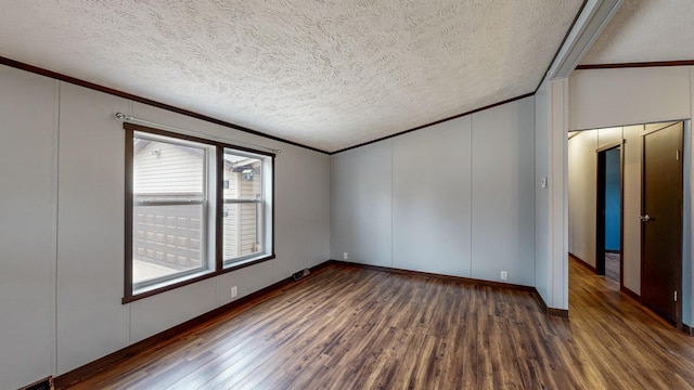 spare room featuring crown molding, dark wood-type flooring, and a textured ceiling