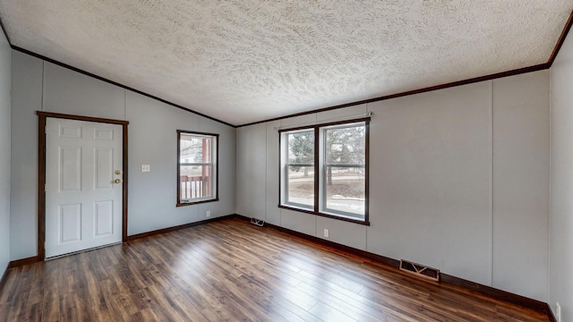 spare room with crown molding, lofted ceiling, a textured ceiling, and dark hardwood / wood-style flooring