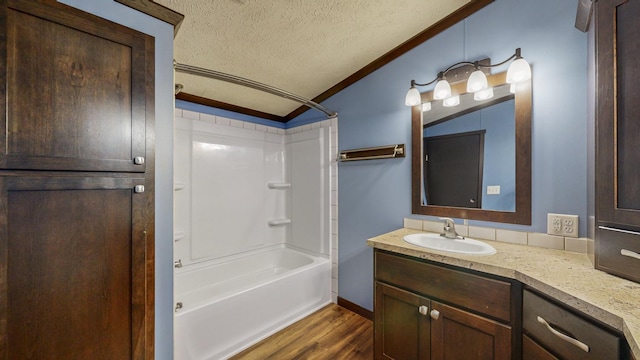 bathroom featuring lofted ceiling, wood-type flooring, ornamental molding, a textured ceiling, and shower / washtub combination