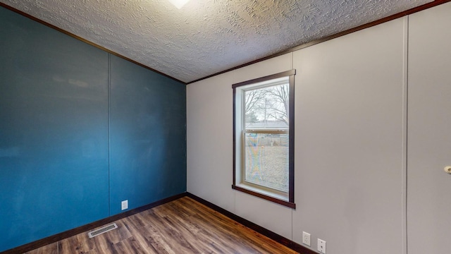 unfurnished room featuring crown molding, dark hardwood / wood-style floors, and a textured ceiling