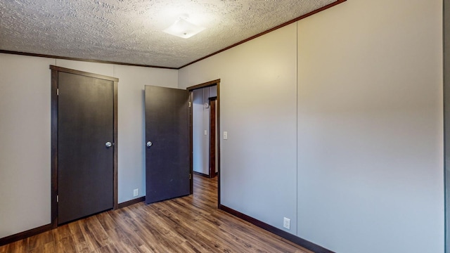 unfurnished bedroom featuring ornamental molding, dark wood-type flooring, and a textured ceiling