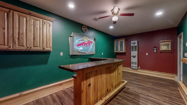 bar featuring ceiling fan and dark hardwood / wood-style floors