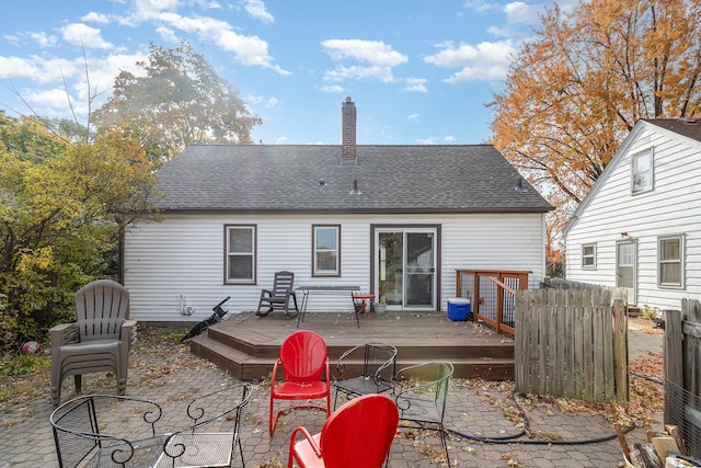 rear view of house featuring a wooden deck and a patio