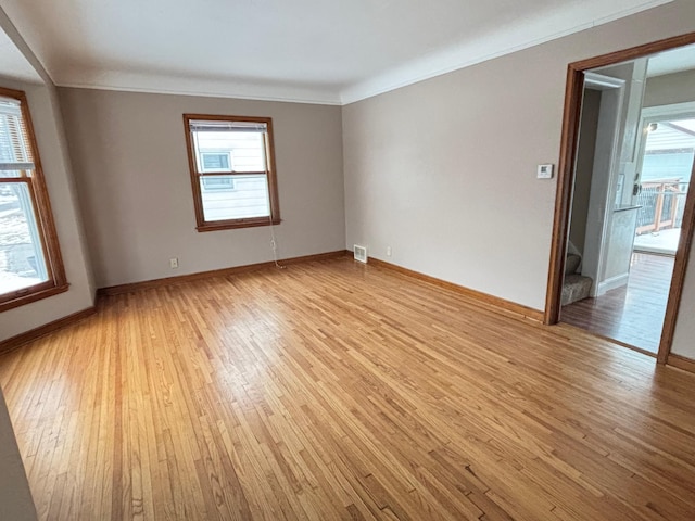 empty room featuring crown molding and light wood-type flooring