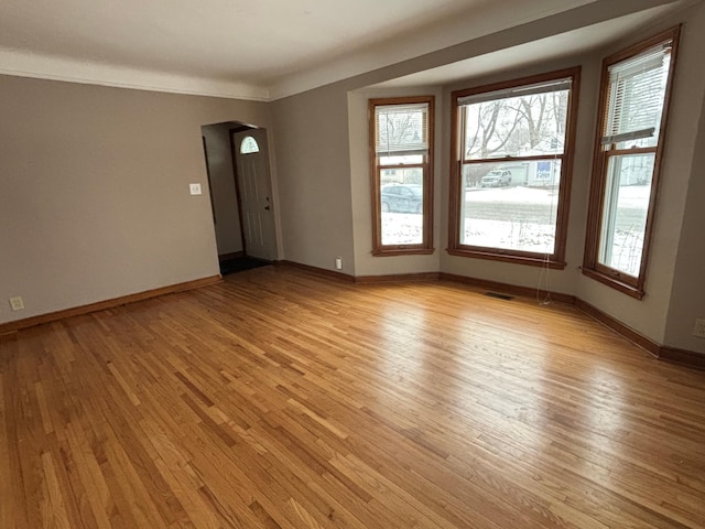 unfurnished room featuring crown molding and light hardwood / wood-style flooring