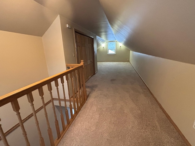 hallway with lofted ceiling and carpet