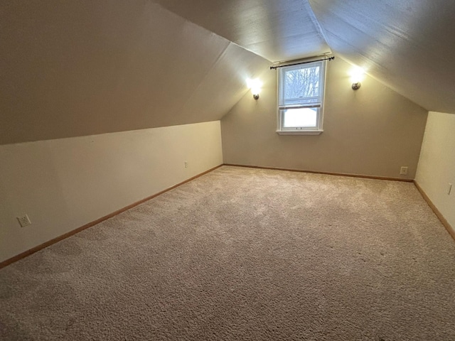 additional living space with vaulted ceiling and carpet