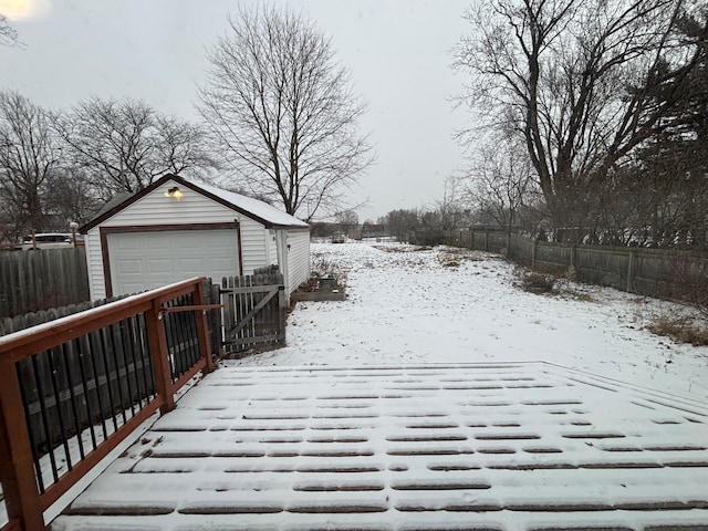 snowy yard with a garage and an outdoor structure