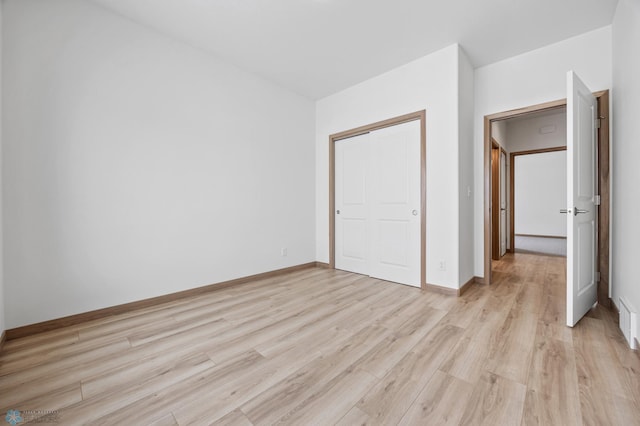 unfurnished bedroom featuring light hardwood / wood-style floors and a closet