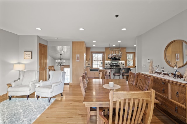 dining space with an inviting chandelier and light hardwood / wood-style flooring