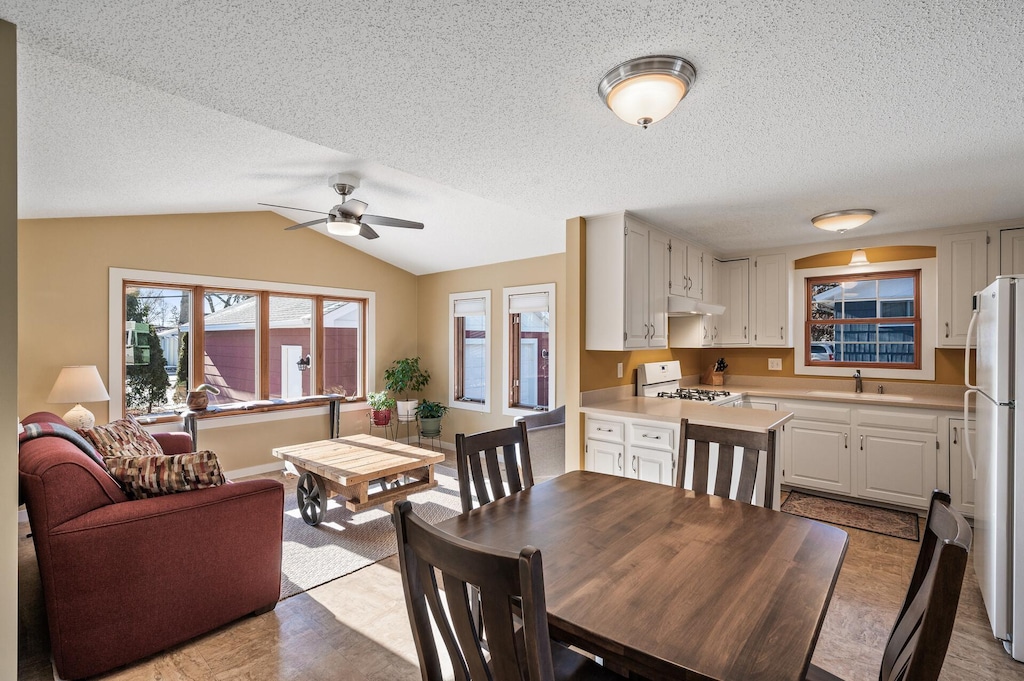 dining area featuring vaulted ceiling, ceiling fan, and sink