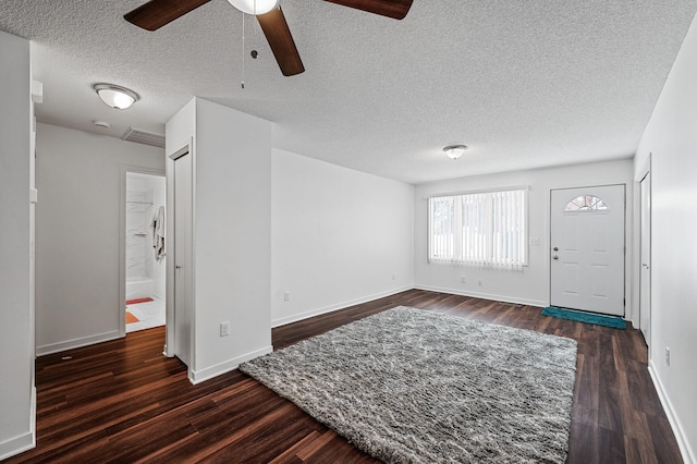 foyer with dark wood-type flooring and a textured ceiling