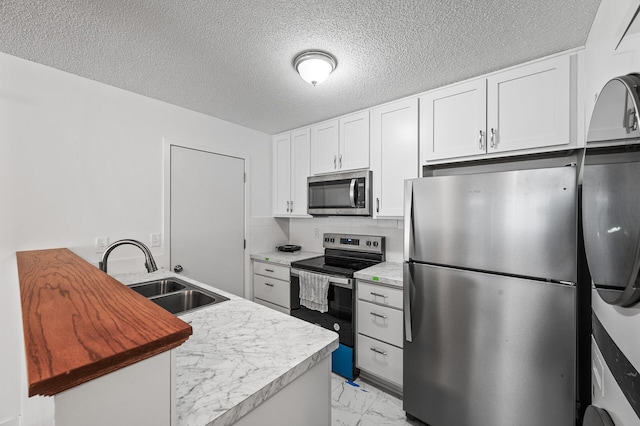 kitchen with white cabinetry, sink, decorative backsplash, stainless steel appliances, and a textured ceiling