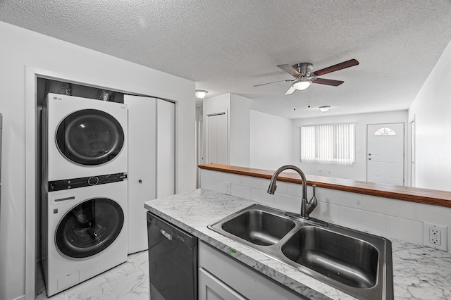 kitchen featuring sink, black dishwasher, ceiling fan, stacked washing maching and dryer, and decorative backsplash