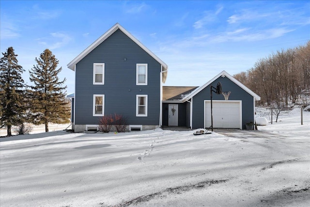 snow covered rear of property with a garage