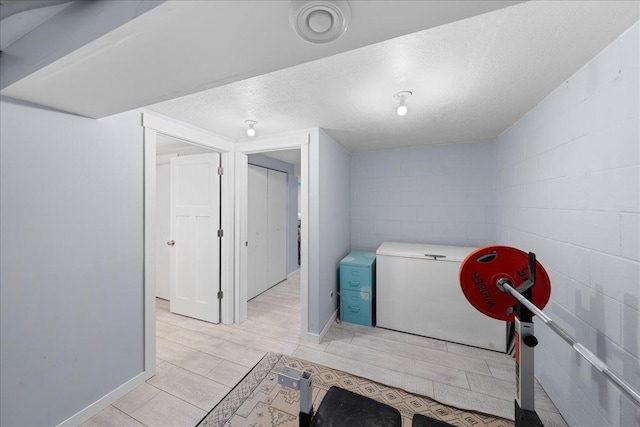 clothes washing area featuring a textured ceiling