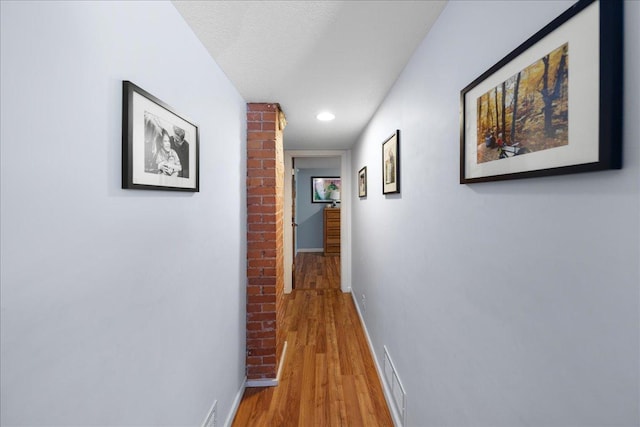 hallway featuring a textured ceiling and light wood-type flooring