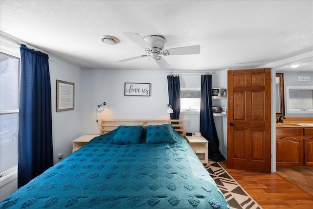 bedroom with wood-type flooring, sink, a textured ceiling, and ceiling fan