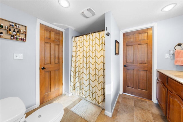 bathroom featuring vanity, toilet, and walk in shower