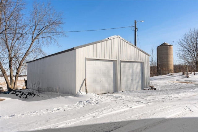 snow covered garage featuring a detached garage