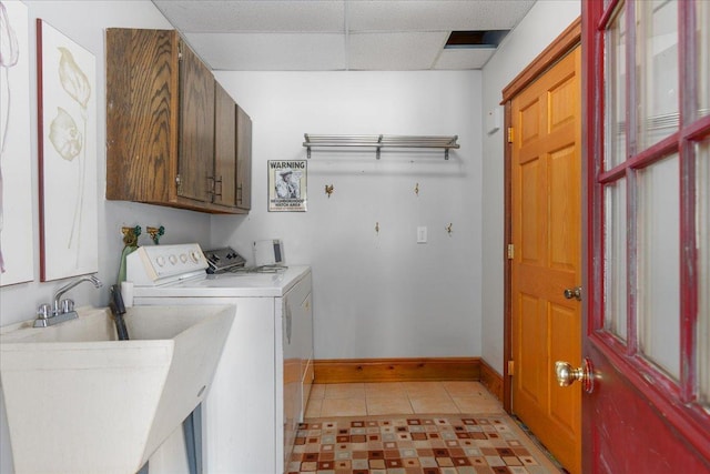 laundry room with light tile patterned flooring, a sink, baseboards, cabinet space, and washer and clothes dryer