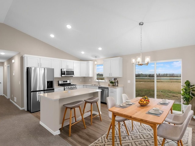 kitchen featuring stainless steel appliances, a center island, sink, and white cabinets