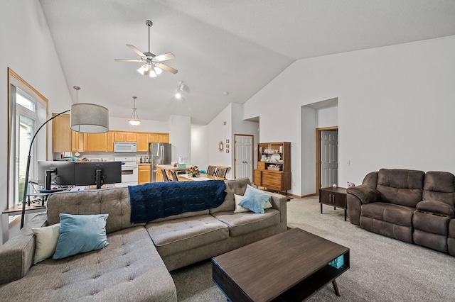 carpeted living room featuring vaulted ceiling and ceiling fan