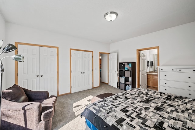 carpeted bedroom featuring two closets and connected bathroom