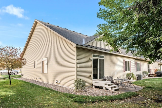 back of house featuring a yard, central AC unit, and a patio area