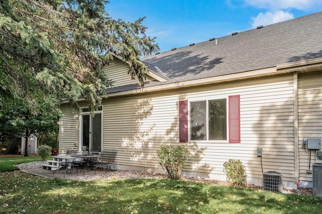 rear view of house featuring a yard, a patio area, central air condition unit, and a storage unit