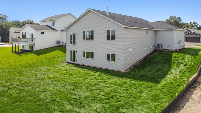 rear view of house with a yard and central AC unit